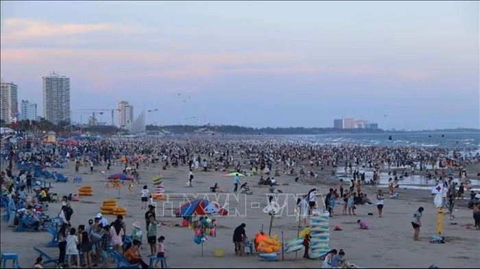 Chiều 30/4, khi nắng dịu và thủy triều thấp, du khách đổ ra khu vực Bãi Sau để vui chơi, tắm biển, trải nghiệm các trò chơi biển.